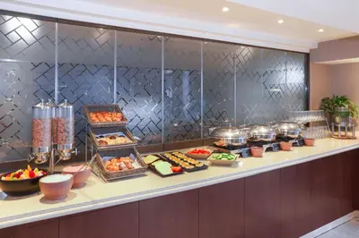 a buffet line with many different types of food at StayEasy Century City in Cape Town