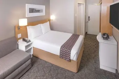 a hotel room with a bed and a television at StayEasy Century City in Cape Town