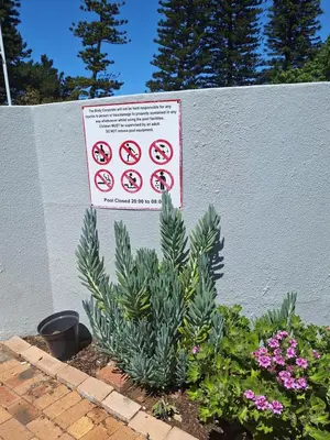 a sign on a wall with some plants and flowers at Serengeti Heide Self Catering Flats in Cape Town