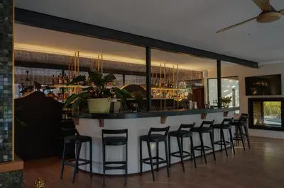 a bar in a restaurant with stools at Vrede en Lust Estate in Simondium