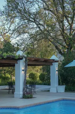 a pavilion with chairs and a swimming pool at Vrede en Lust Estate in Simondium