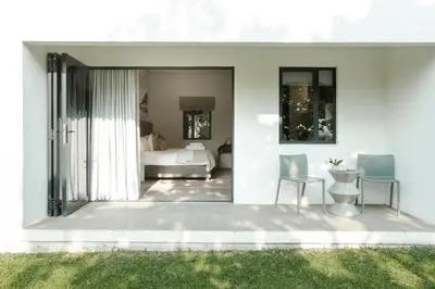 a room with a bed and a table and chairs at Vrede en Lust Estate in Simondium