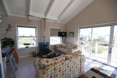 a living room with two couches and two windows at Reddoor Studio in Pringle Bay