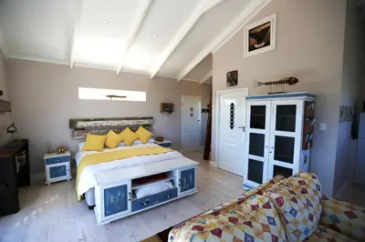 a bedroom with a bed and a couch at Reddoor Studio in Pringle Bay