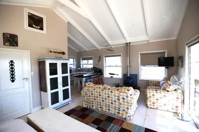 a living room with two couches and a ceiling at Reddoor Studio in Pringle Bay