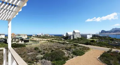 a view of the ocean from the balcony of a house at Reddoor Studio in Pringle Bay
