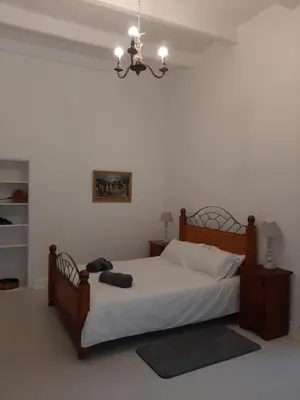 a bedroom with a bed and a chandelier at Mooiplaas Wine Estate in Stellenbosch