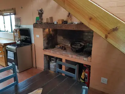 a kitchen with a brick fireplace in a house at Pelagonia in Bettyʼs Bay