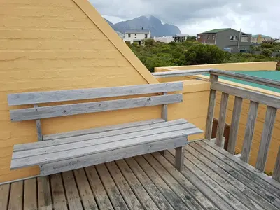 a wooden bench sitting on top of a deck at Pelagonia in Bettyʼs Bay
