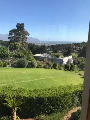 a green field with a house in the background at Wine Cottage by the Sea in Helderberg
