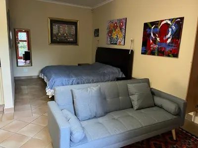 a living room with a couch and a bed at Wine Cottage by the Sea in Helderberg