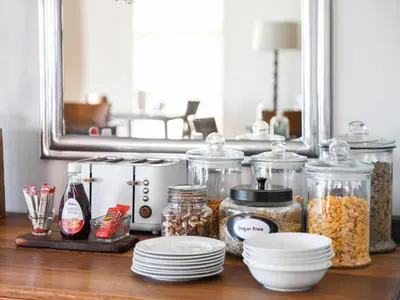 a table with jars of food and plates on it at Four Palms Accommodation in Durbanville