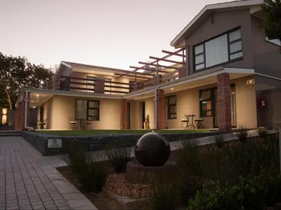 a house with a sculpture in front of it at Four Palms Accommodation in Durbanville