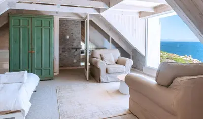 a living room with two chairs and a large window at Pringle Bay Home in Pringle Bay
