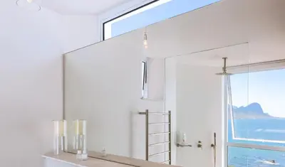 a large mirror in a bathroom with a window at Pringle Bay Home in Pringle Bay