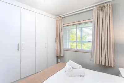 a bedroom with a bed and a window at Lagoon Beach 237A by CTHA in Cape Town