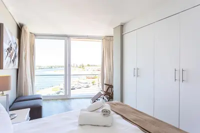 a bedroom with a bed and a large window at Lagoon Beach 237A by CTHA in Cape Town