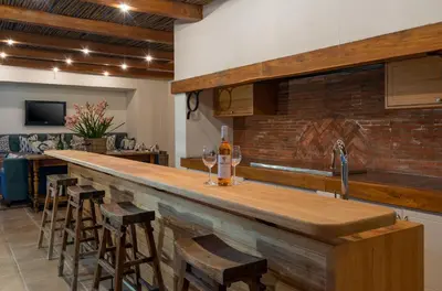 a kitchen with a bar with some wine glasses on it at The Residence @ Vrede & Lust in Franschhoek