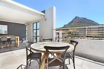 a patio with a table and chairs on a balcony at The Paragon 317 in Cape Town