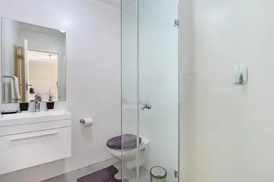 a bathroom with a toilet and a glass shower at The Paragon 317 in Cape Town