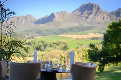a table with wine glasses and a view of mountains at Webersburg in Stellenbosch