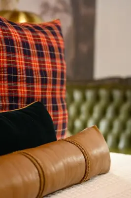 a brown leather wallet sitting on top of a bed at Webersburg in Stellenbosch