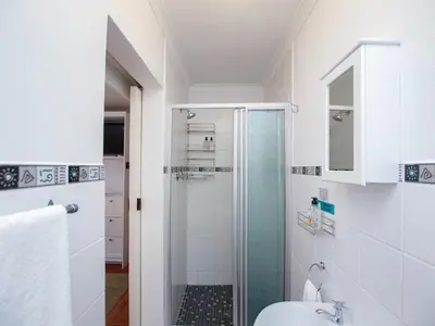 a bathroom with a shower and a sink at Eikelower Accommodation in Stellenbosch