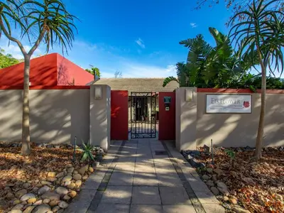 a house with a red door and palm trees at Eikelower Accommodation in Stellenbosch