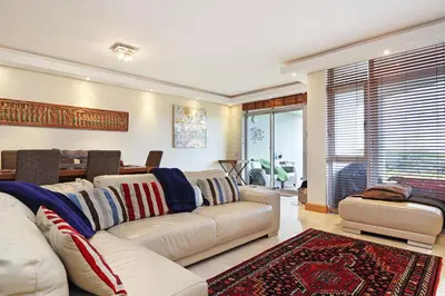 a living room with a white couch and a table at Dolphin Beach E5 in Bloubergstrand