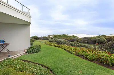 a view of a garden from the side of a house at Dolphin Beach E5 in Bloubergstrand
