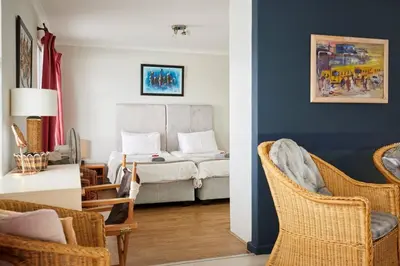a living room with a couch and chairs in it at The Rondebosch in Cape Town