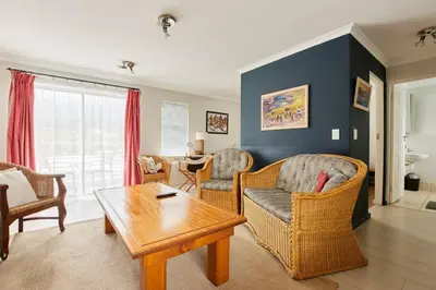 a living room with chairs and a coffee table at The Rondebosch in Cape Town