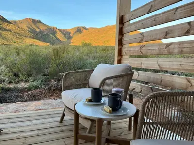 two chairs and a table with two cups on a porch at Riverbend Farm in Robertson