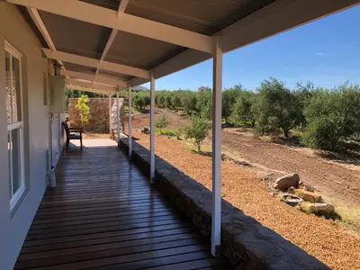 a porch of a house with a wooden deck at Riverbend Farm in Robertson