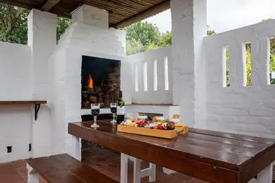 a room with a fireplace and a table with food at Ridgeworth Cottage in Greyton