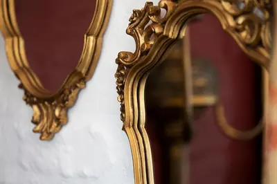 a gold mirror is hanging on a wall at Ridgeworth Cottage in Greyton