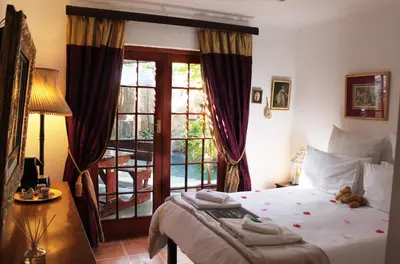 a bedroom with a bed with a teddy bear on it at Goblin's Mead in Edgemead
