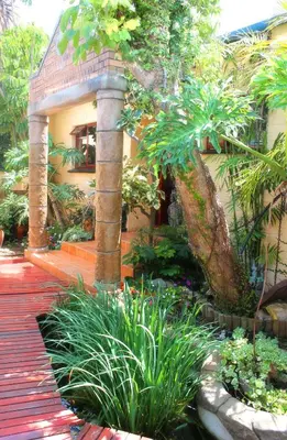 a house with a bunch of plants in front of it at Goblin's Mead in Edgemead