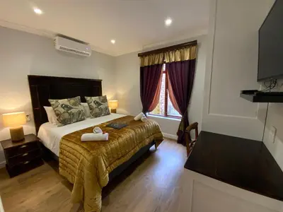 a bedroom with a bed with two towels on it at Goblin's Mead in Edgemead