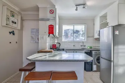 a kitchen with a counter and a refrigerator at 155 hbc in Hermanus
