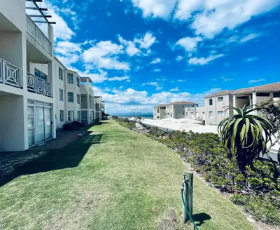 a walkway between two buildings with a palm tree at 155 hbc in Hermanus