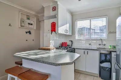 a kitchen with white cabinets and a granite counter top at 155 hbc in Hermanus