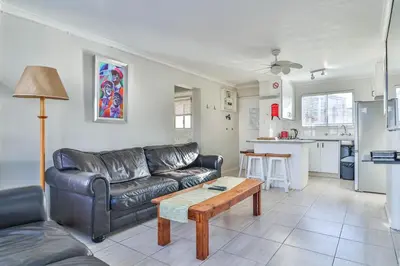 a living room with a leather couch and a table at 155 hbc in Hermanus