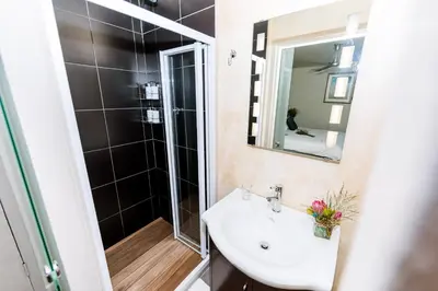 a bathroom with a sink and a mirror at Le Petit Chateau Guest House in Durbanville
