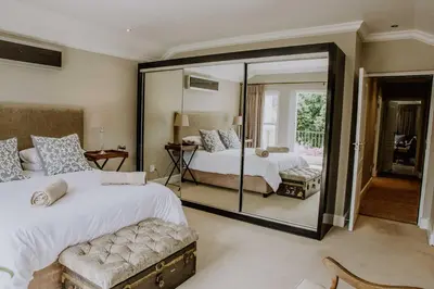a bedroom with two beds and a large mirror at Franschhoek Village House in Franschhoek