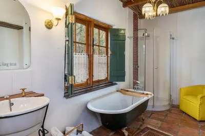 a bathroom with a bath tub and a sink at Oude Wellington Estate in Wellington