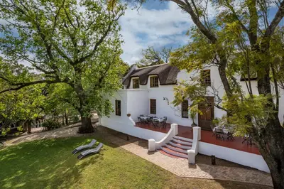 a white house with a porch and a yard at Oude Wellington Estate in Wellington