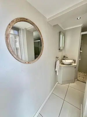 a bathroom with a mirror and a sink at Oakvale Lodge in Cape Town