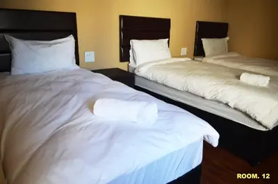 two beds in a hotel room with white sheets at ST@Y-1-BnB in Cape Town