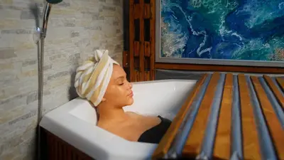 a woman sitting in a bath tub with a towel on her head at Gaia Hydro-Spa and Guest House in Cape Town